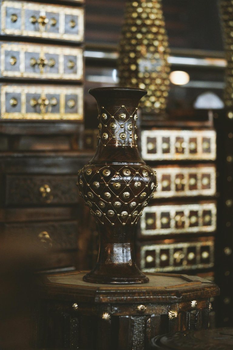 Beautifully crafted traditional Indian vase with gold accents in a luxurious setting.