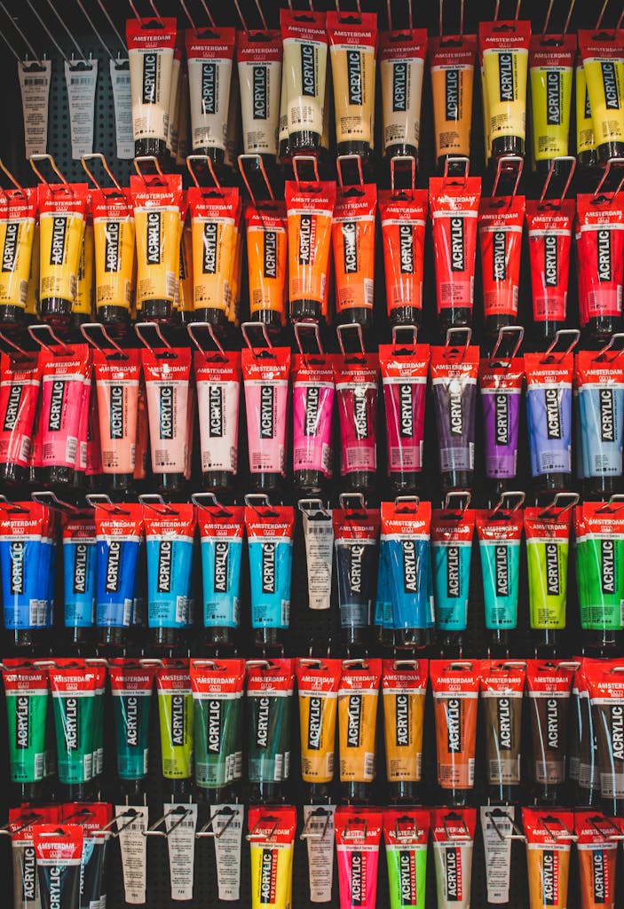 A colorful array of acrylic paint tubes neatly arranged on a shelf, ready for artists.