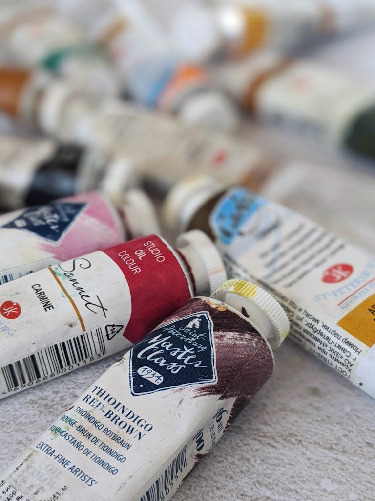 A variety of colorful oil paint tubes spread out, capturing an artist's workspace vibe.