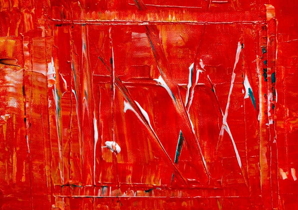 Dynamic abstract acrylic painting with rich red textures on canvas.