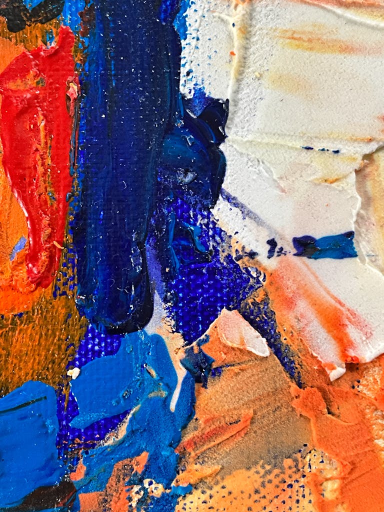 Dynamic close-up of colorful abstract oil painting texture with bold strokes and vibrant colors.