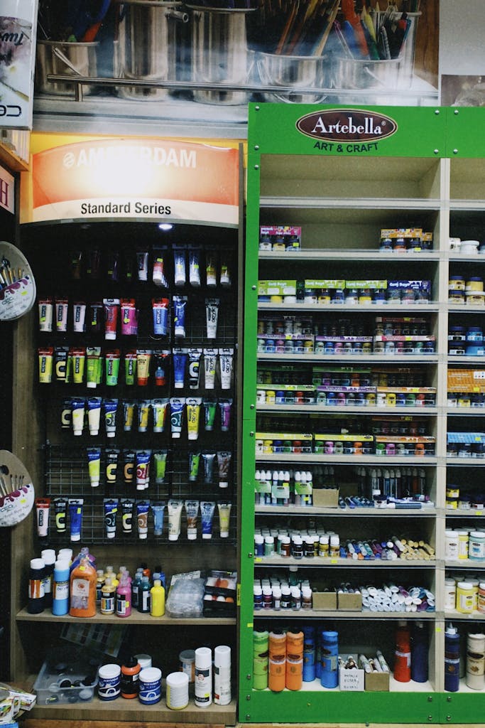 Vibrant shelves of art supplies in a retail store, featuring various paints and art materials.